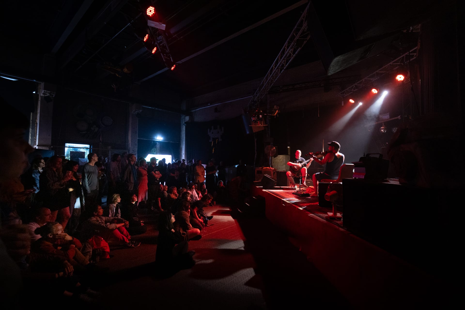Max met Rauwslinger op het podium in Amsterdam terwijl mensen aandachtig luisteren